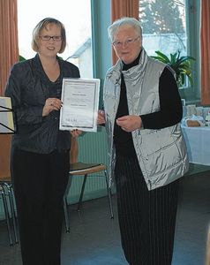 Carolin Evers von der Fachstelle für Büchereiarbeit im Bistum Limburg überreicht Marianne Benner die silberne Ehrennadel für Büchereiarbeit